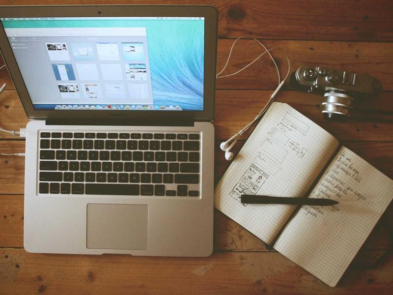 Wireframe sketches and sticky notes on a white desk, product planning session, top-down flat lay, natural daylight, minimal aesthetic